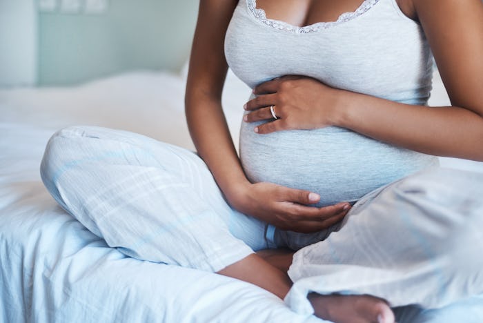 A black expecting mom sitting on a bed; new report from the Centers for Disease Control and Preventi...
