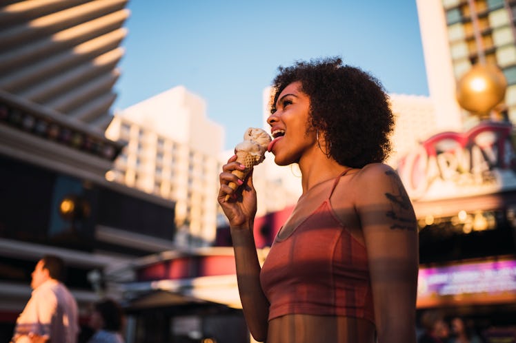 A woman licks an ice cream cone outside of a hotel in Las Vegas, Nevada.