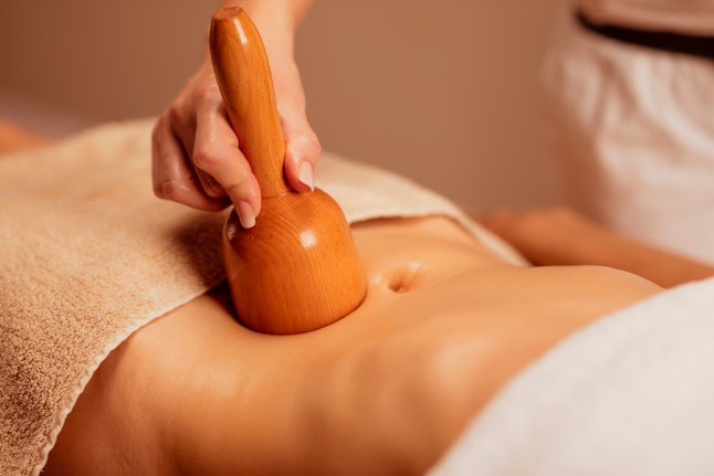A woman gets treatment on her stomach. Stress can change the gut microbiome and affect digestion and constipation.