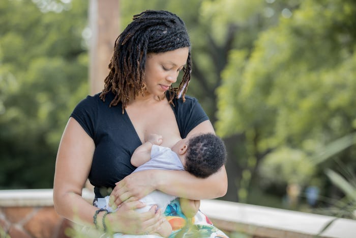 a woman breastfeeding her baby outside