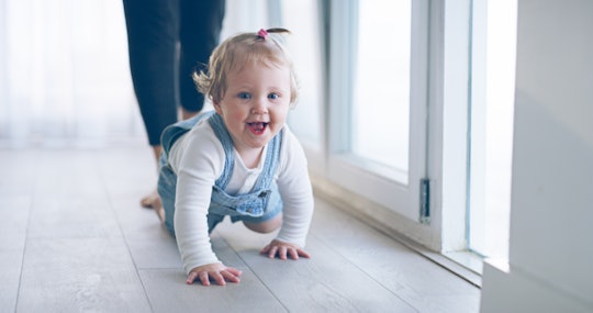 a baby girl crawling down a hallway