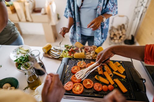 A family cooks a meal of grilled vegetables. The term "clean eating" is often too vague to be meanin...