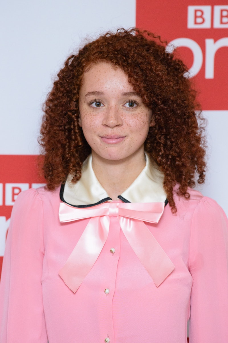 Erin Kellyman with a red curly hair, wearing a pink blouse with a bow and a white satin collar on a ...