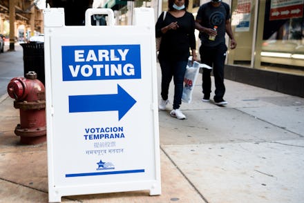 An white and blue early voting sign placed on a pedestrian 