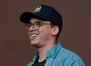Logic the rapper can be seen in a hat, smiling at his audience.