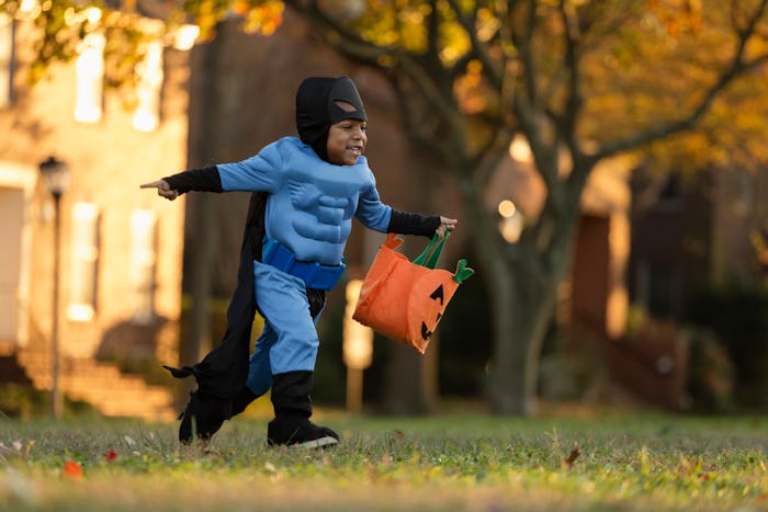 little boy running with a halloween bag