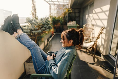 A woman puts her feet up while drinking coffee on a screened in porch. Here are breast cancer stats ...