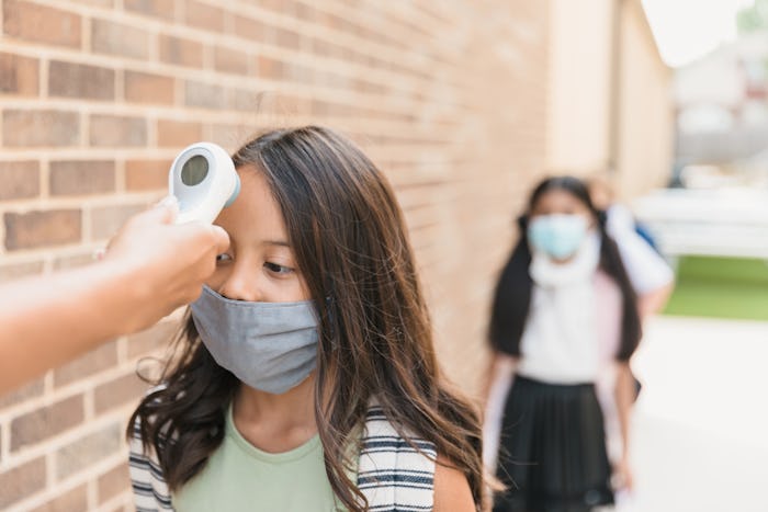 little girl getting her temperature taken at school