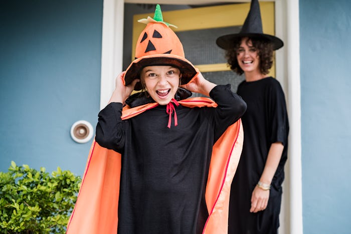 mom and daughter in witch costumes leaving house