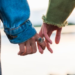 A couple holds hands. Empaths are people with heightened sensitivity to others, and a therapist expl...