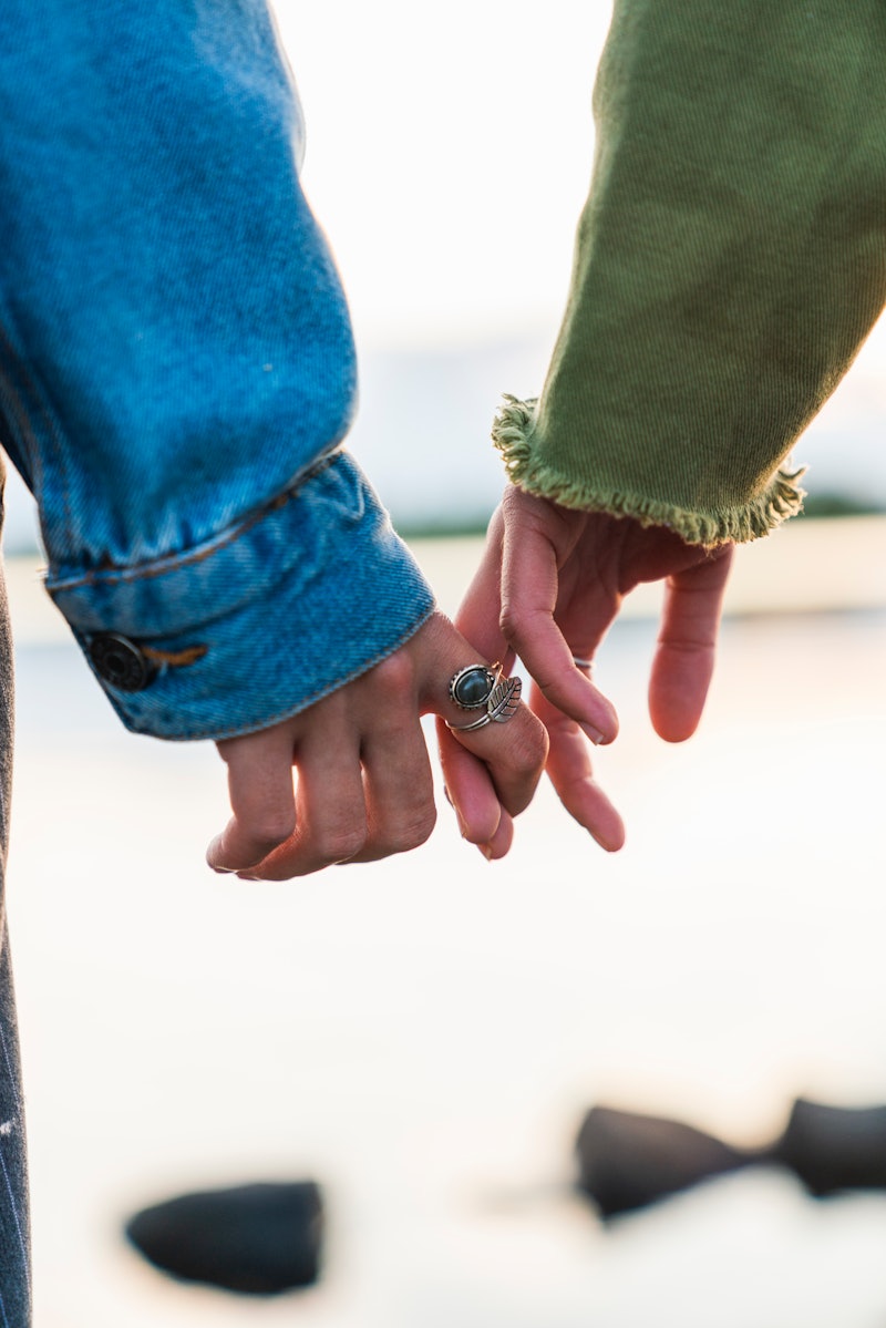 A couple holds hands. Empaths are people with heightened sensitivity to others, and a therapist expl...
