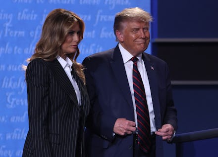 Donald Trump and Melania Trump standing together on a stage and smiling
