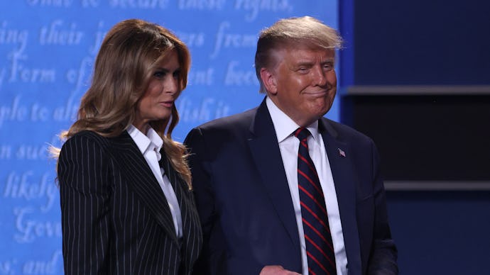 Donald Trump and Melania Trump standing together on a stage and smiling