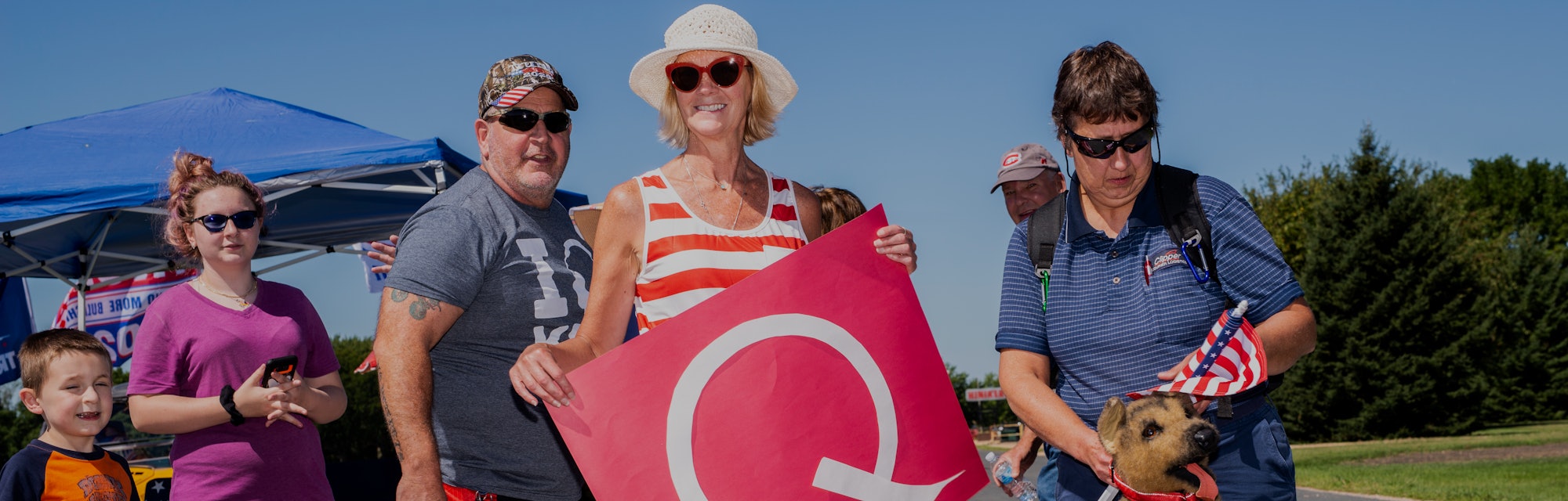A QAnon supporter can be seen holding a Q for the movement.