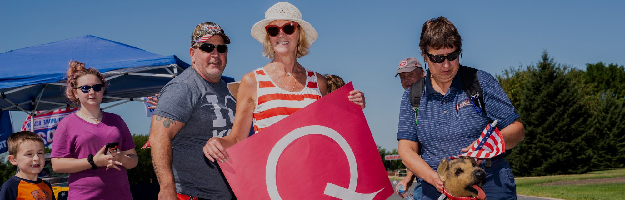 A QAnon supporter can be seen holding a Q for the movement.