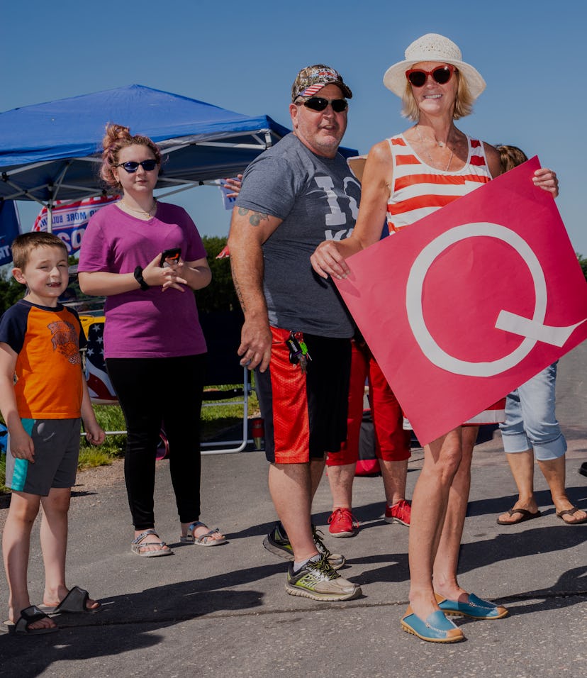 A QAnon supporter can be seen holding a Q for the movement.