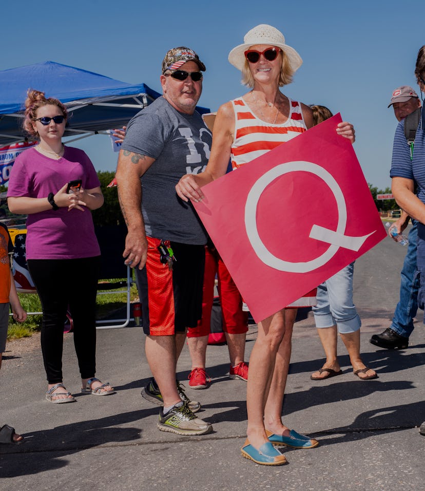 A QAnon supporter can be seen holding a Q for the movement.