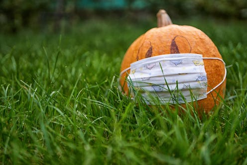 A Halloween pumpkin wears a mask. A doctor explains how to safely celebrate halloween 2020 during th...