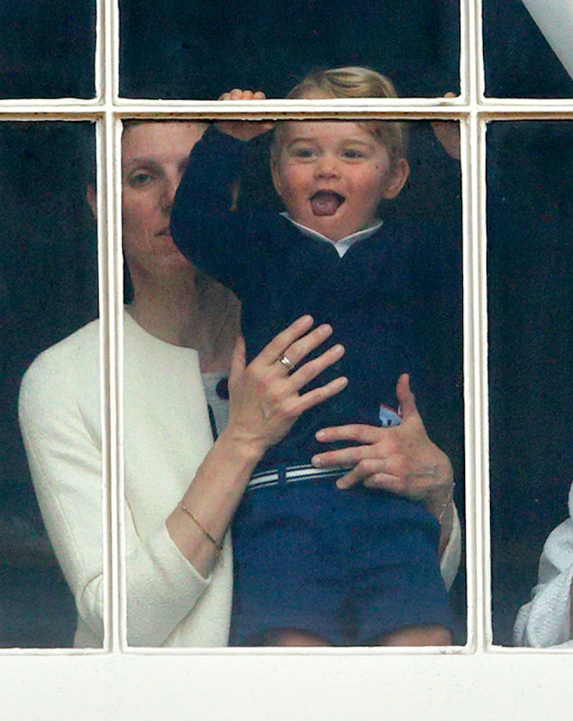 Prince George peeks out his window while dressed in a blue sweater