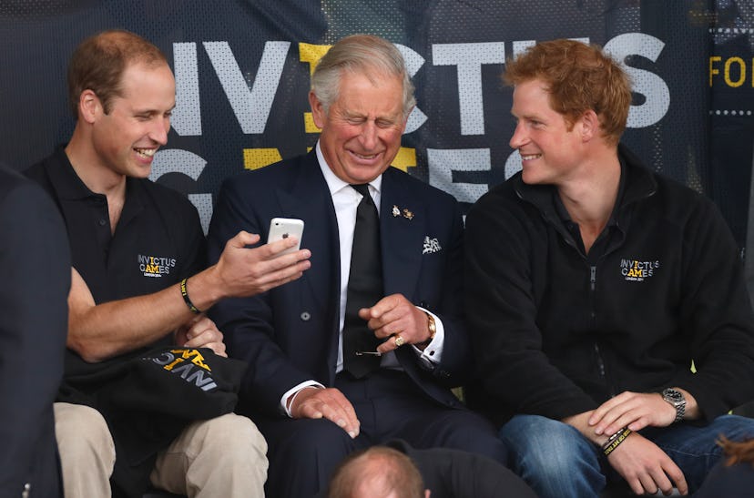 Prince William shares something funny from his phone with his father and brother.