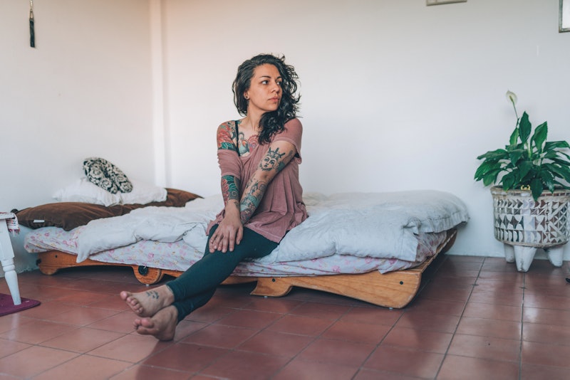 A woman with tattoos sits up in bed. These are 6 causes of diabetes that have nothing to do with foo...