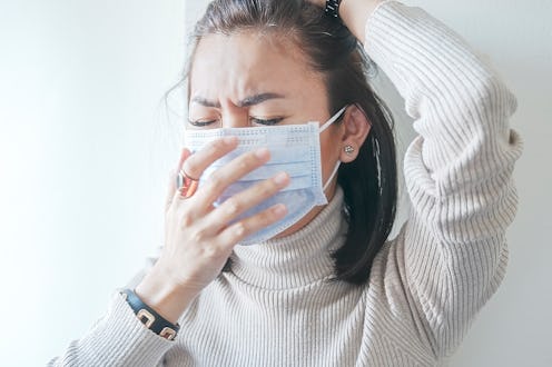 A person wearing a mask covers her nose with one hand. There are some key differences between corona...