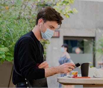 Man wearing AirPods and a face mask.
