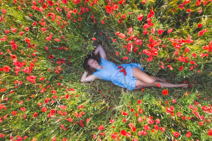 A woman dreaming in a field of flowers. Déjà rêvé is the experience of feeling like you've dreamed s...