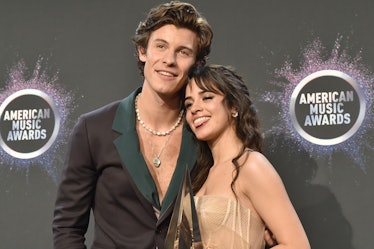 Shawn Mendes and Camila Cabello posing at an event, Shawn is smiling while Camila sticks her tongue ...