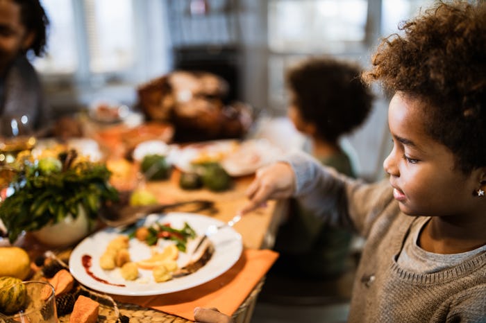 little girl eating at thanksgiving table
