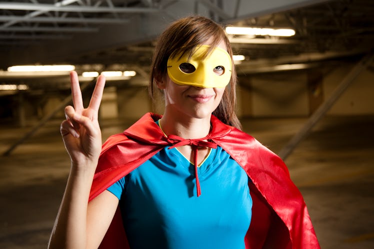 A woman wearing a superhero costume gives a peace sign, for which she needs a superhero costume capt...