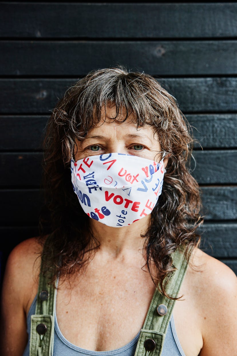 A woman wears a voting face mask. Voters responded to a Bustle and Mic survey on voting and covid op...