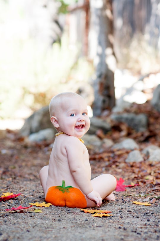 baby with a pumpkin painted on its butt