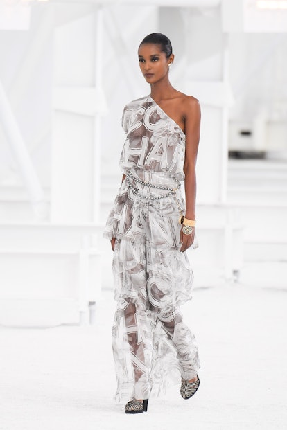 The one-shoulder, white sheer maxi dress with a logo from Chanel's Spring 2021 Collection.