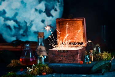 A box with sparks coming out of it is surrounded by spooky potions and crystals.