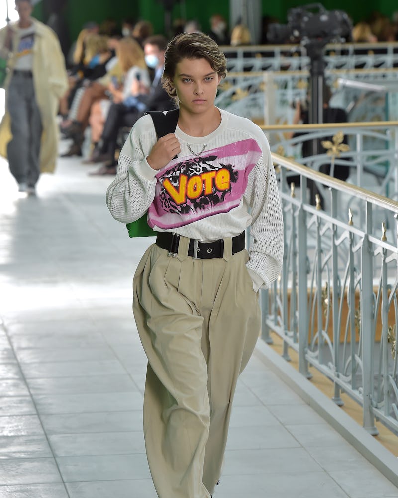 A model wearing clothing from the Louis Vuitton's Spring 2021 women's collection with a white sweate...