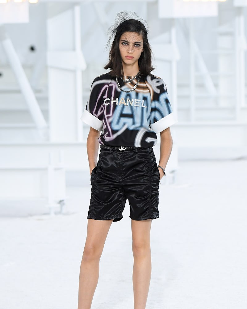 Chanel's Spring 2021 look with logo T-shirt paired with black satin short pants.