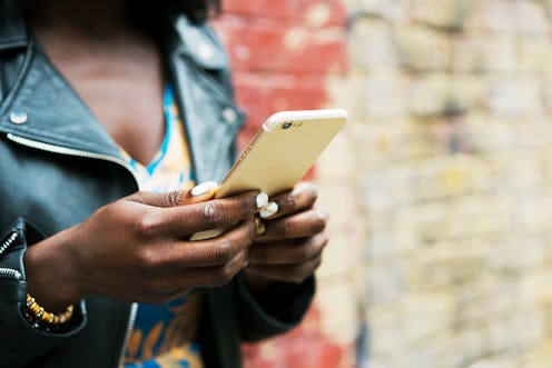 A woman in a leather jacket looks at instagram on her phone. Experts explain that instagram does hav...