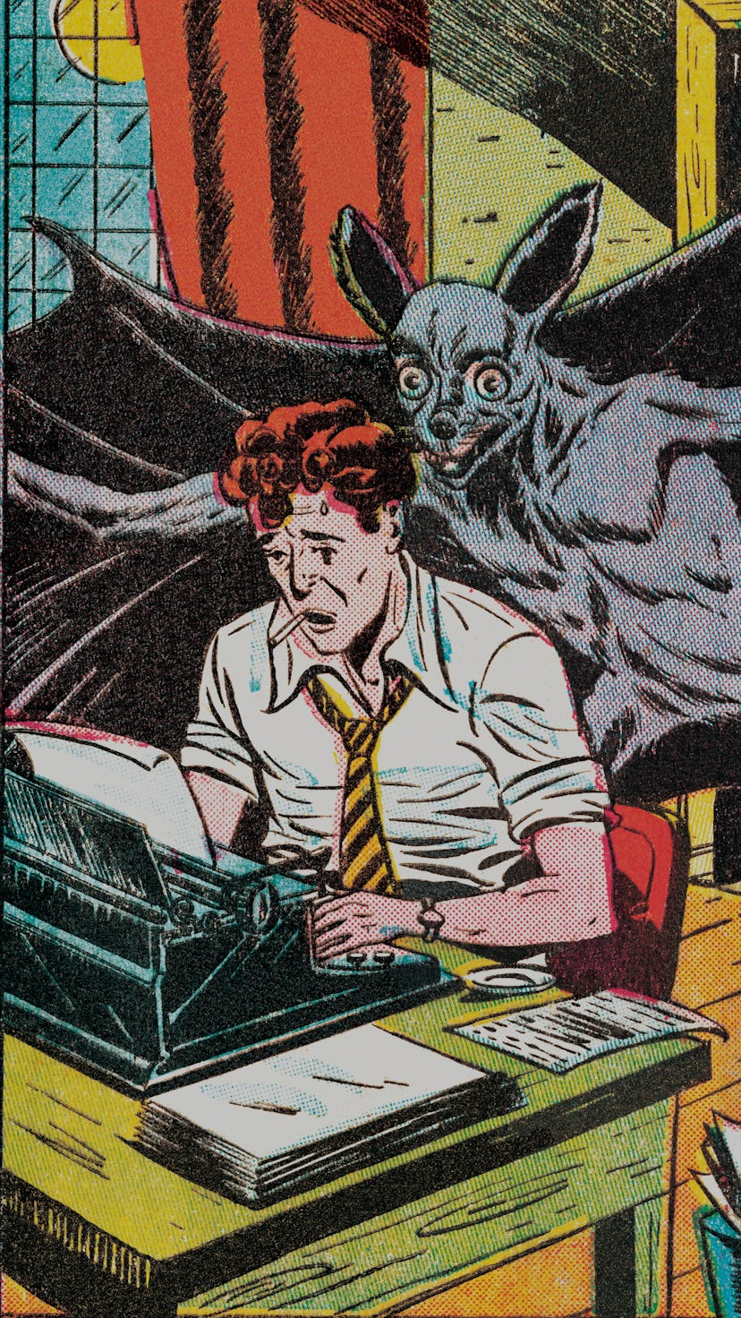 A man typing with a bat leaning over his shoulder.