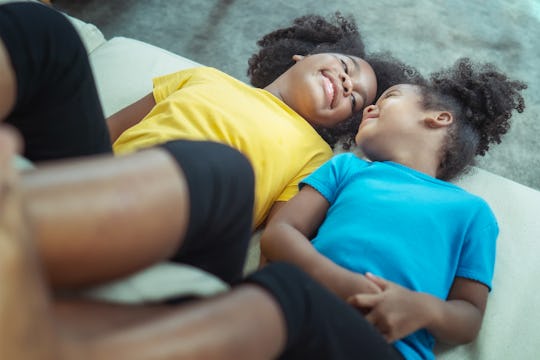 two sisters lying next to each other, hanging out