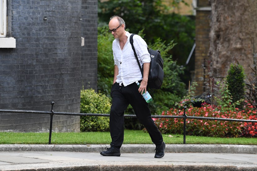 Dominic Cummings walking into Downing Street wearing a crumpled white shirt and black tracksuit bott...