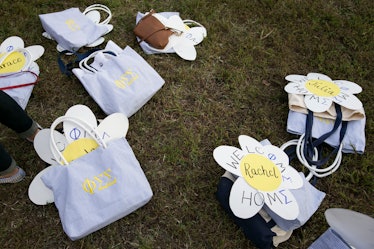 Striped totes filled with crafts and goodies for new sorority members lay on the grass.