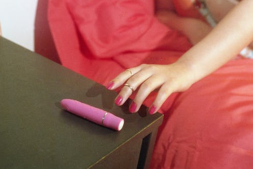 A woman in bed reaching for her pink womanizer pro40