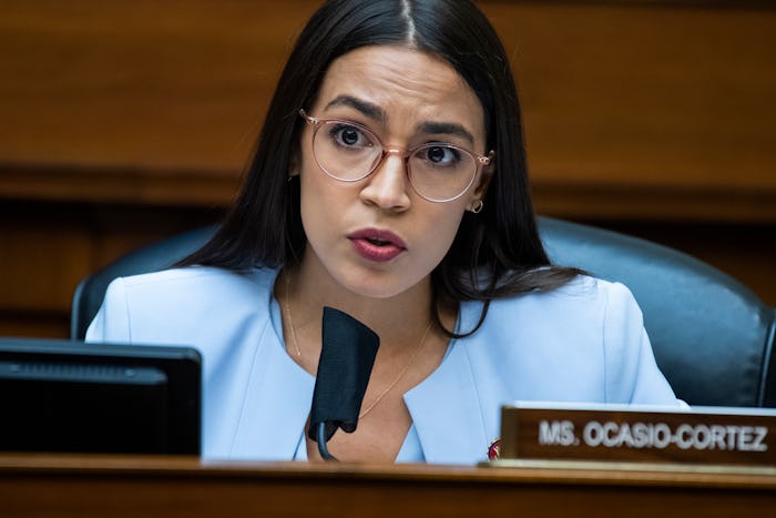 Alexandria Ocasio-Cortez speaking in a blue suit