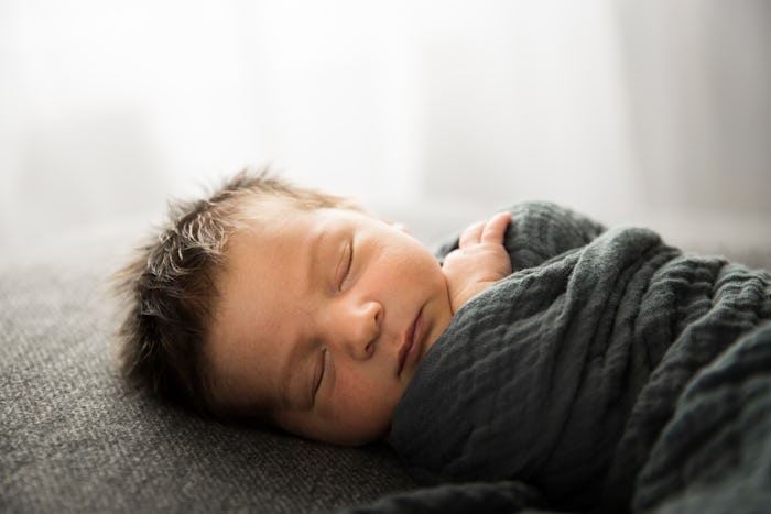newborn baby in gray blanket