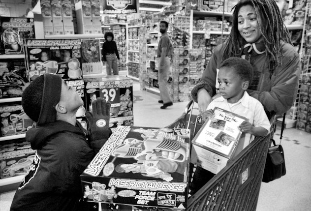 A mother shops with children at a toy store for a Tickle Me Elmo.