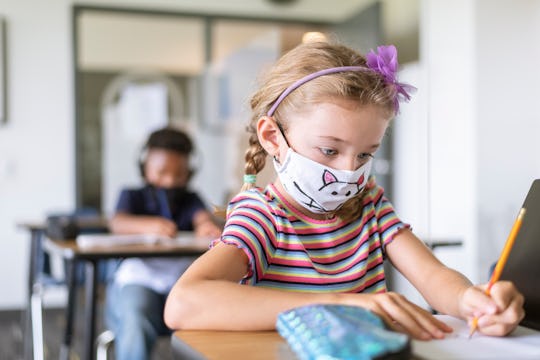 little girl in mask at school