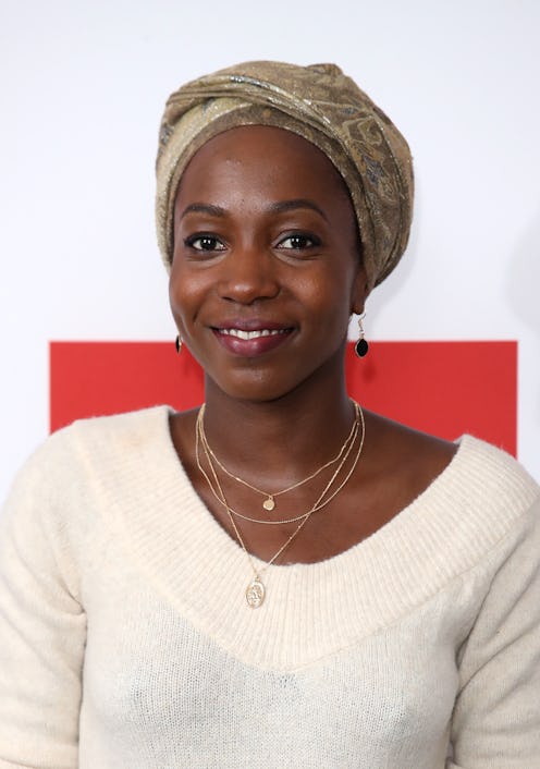 Tamara Lawrance wearing a cream v-neck jumper, gold jewellery and a khaki, cream and gold head wrap