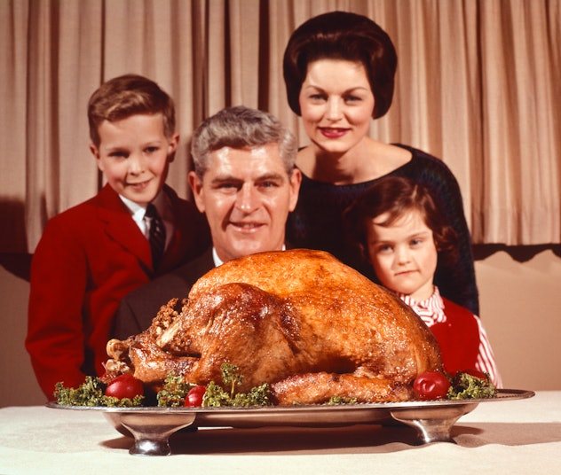 Family poses with turkey.
