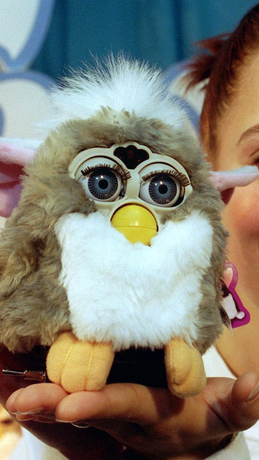 A woman holding a Furby